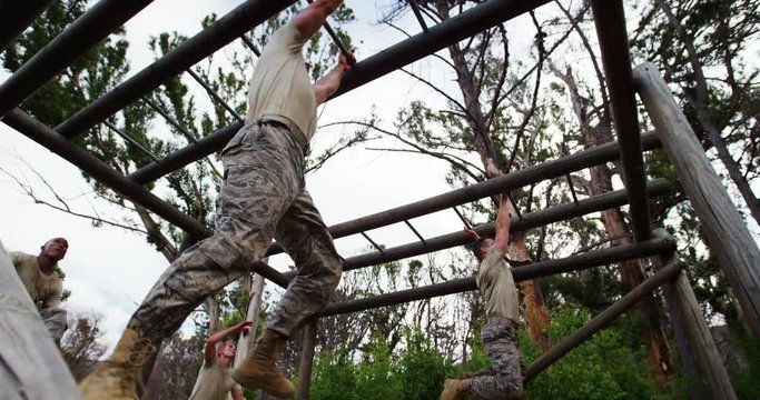 Military soldiers climbing monkey bars 