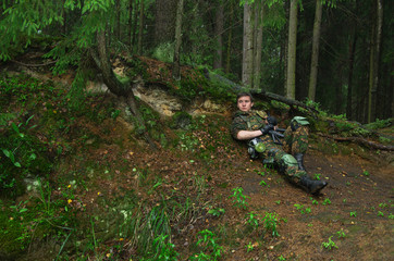 soldier hiding and resting over the hill in the woods