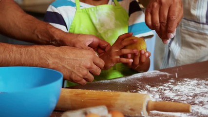 Multi-generation family preparing dessert in kitchen