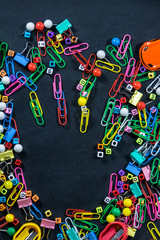 Top view of colorful office equipment with copy space on black chalkboard background. Education concept.