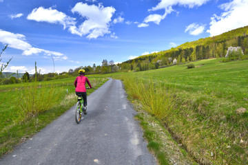 Obraz premium Woman riding a bicycle on a sunny spring day