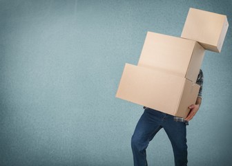 Delivery man carrying stacked boxes