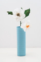 Open centered crepe paper dahlia in a vase on white