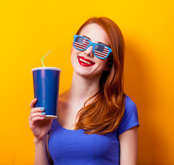 redhead girl with movie cola and eyeglasses