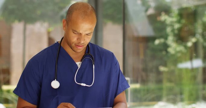 4K Portrait smiling doctor with digital tablet in modern private hospital. Slow motion