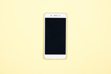 Smartphone on yellow background with copy space. Flat lay. Top view. Minimal style.