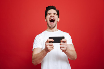 Portrait of a happy young man in white t-shirt celebrating