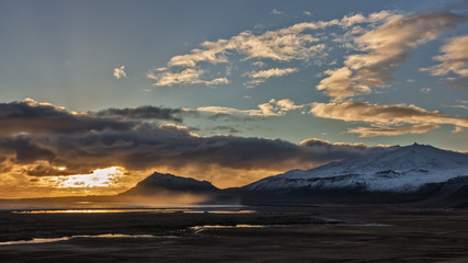 Fototapeta na wymiar Mist Rises over the Bay as the Autumn Sun Sets Over the Icelandic Volcano Snaefellsjokull