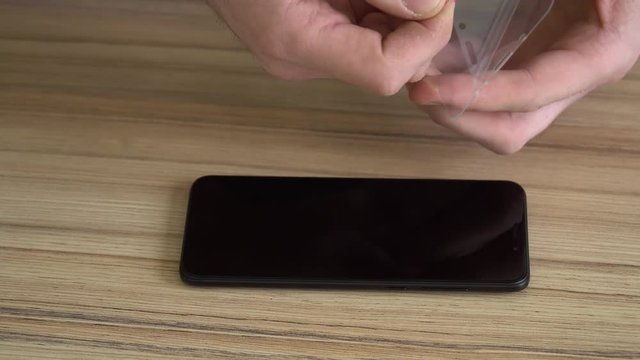 Close-up. Preparing the screen for a new mobile phone. Cleaning with a damp cloth. New protective, chopped, shockproof glass.