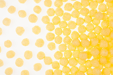 Yellow corn sticks balls on white background, pattern, top view.