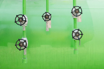 Close-up Industrial Valve contain the gas, oil or water on the pipeline. Processing Plant operates by opening, closing and isolate valve with the steel pipe and equipment on the green background