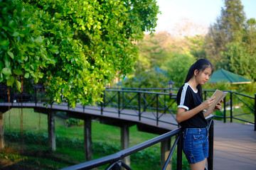 Fototapeta premium Teen girl relax after reading book in park, outdoor, education concept