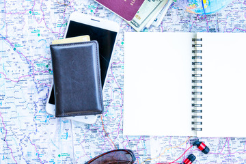 Top view of travel notebook with smart phone  camera and travel map background. Journey concept.