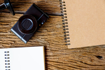 Top view of notebok with pencil, smart phone and calculator on wooden table. Emtry page for text.