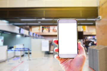 People hand use cellphone at the hall airport background with copy space on screen for using mobile app about activities in the airport or checking flight plan