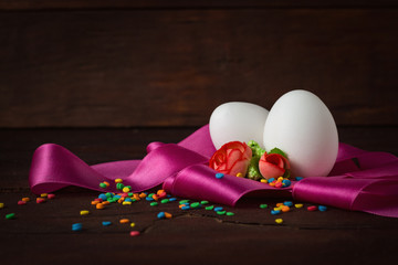 Eggs, Pink Tape, Colored Sweets, Flowers on the Wooden Background. Easter concept