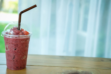 mixed berries smoothie on wood table. delicious blended yogurt beverage with blueberry, raspberry &...