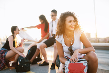 Four friends on a vacation in a city taking a break to rest from long walking on a beautiful day.