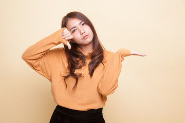 Fototapeta premium Young Asian woman show palm hand and thumbs down.