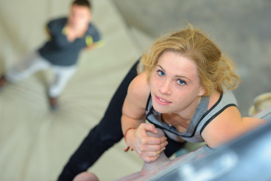Portrait of woman climbing indoor wall