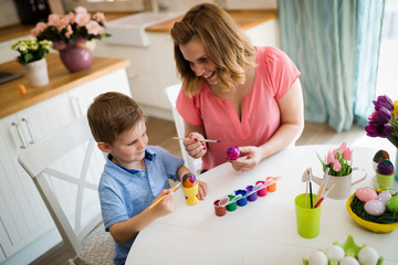 Obraz na płótnie Canvas Mother and son paint Easter eggs