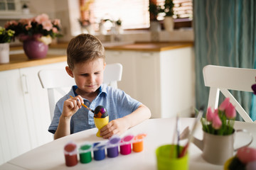 Beautiful child painting eggs for easter
