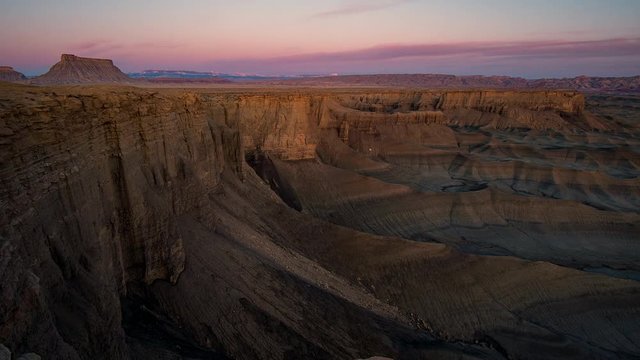 Sunrise time lapse lighting up Factory Butte and cliffs in the desert near Hanskville Utah.