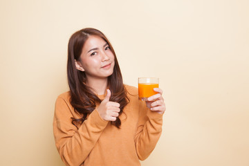 Young Asian woman thumbs up drink orange juice.