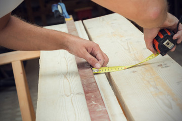 Fototapeta na wymiar Carpenter working on the raw board / wood.