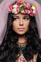 Brunette Woman with Makeup and Flowers Hairstyle. Female Face Close up