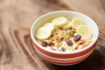 Healthy breakfast, muesli with cereal, slice banana and milk in a bowl