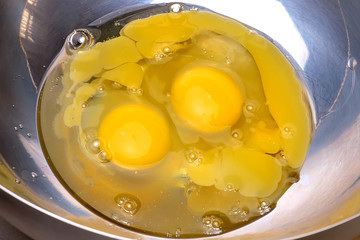 Broken eggs in the shiny iron Cup