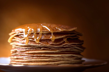 Pancakes with honey on a Golden background.