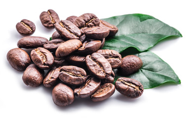 Roasted coffee beans and leaves on white background.