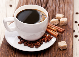 Cup of coffee, coffee beans and sugar cubes. Close-up.