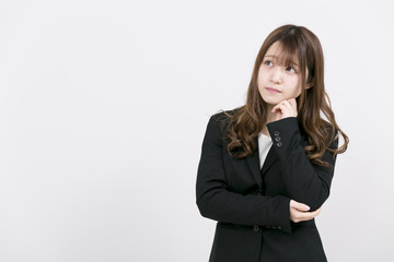 悩むスーツの女性