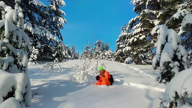 Man with camera taking photo outdoors in winter snowy landscape.