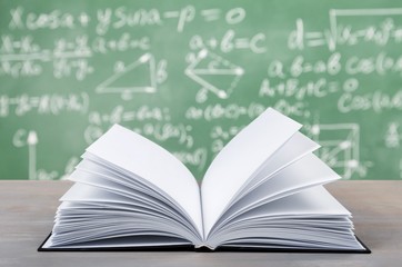 Book on desk on formulas background