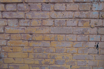 Weathered brick wall with remains of paint texture