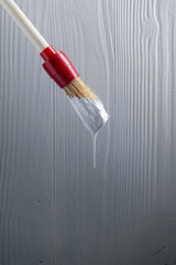Paintbrush with white paint .