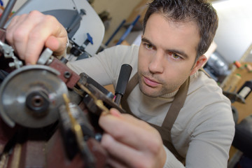 Man using bench mounted grinder
