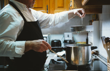 Man of 59 year old working in the kitchen of his house.