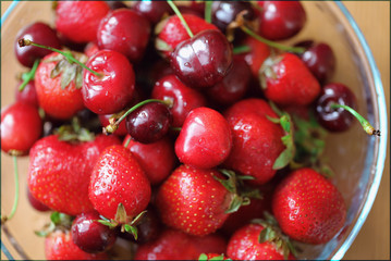 Strawberries and cherry berries in bowl. Close up. Top view.
