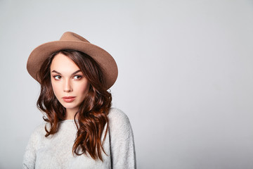 Portrait of young stylish laughing girl model in gray casual summer clothes in brown hat with natural makeup isolated on gray background. Looking at camera