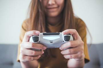 Closeup image of an asian woman holding the game controller while playing games with feeling fun and happy © Farknot Architect