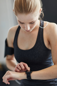 Junge Frau kontrolliert Leistung mit Smartwatch
