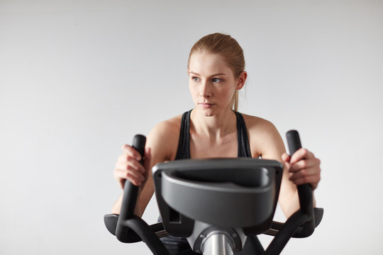 Junge Frau trainiert auf dem Hometrainer