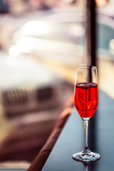 Red Cocktail in Champagne Glass near the Window in the Bar with Amazing Blurred Background, Free Space for Text