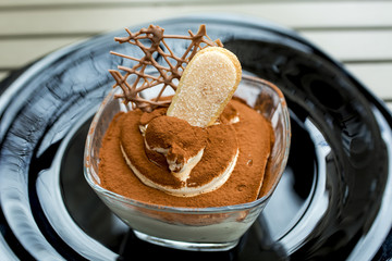 Traditional Italian dessert tiramisu decorated with cocoa 