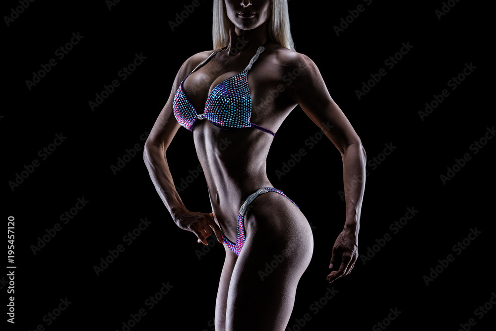 Wall mural cose-up photo perfect female bikini model posing on black background attractive female athlete bodyb